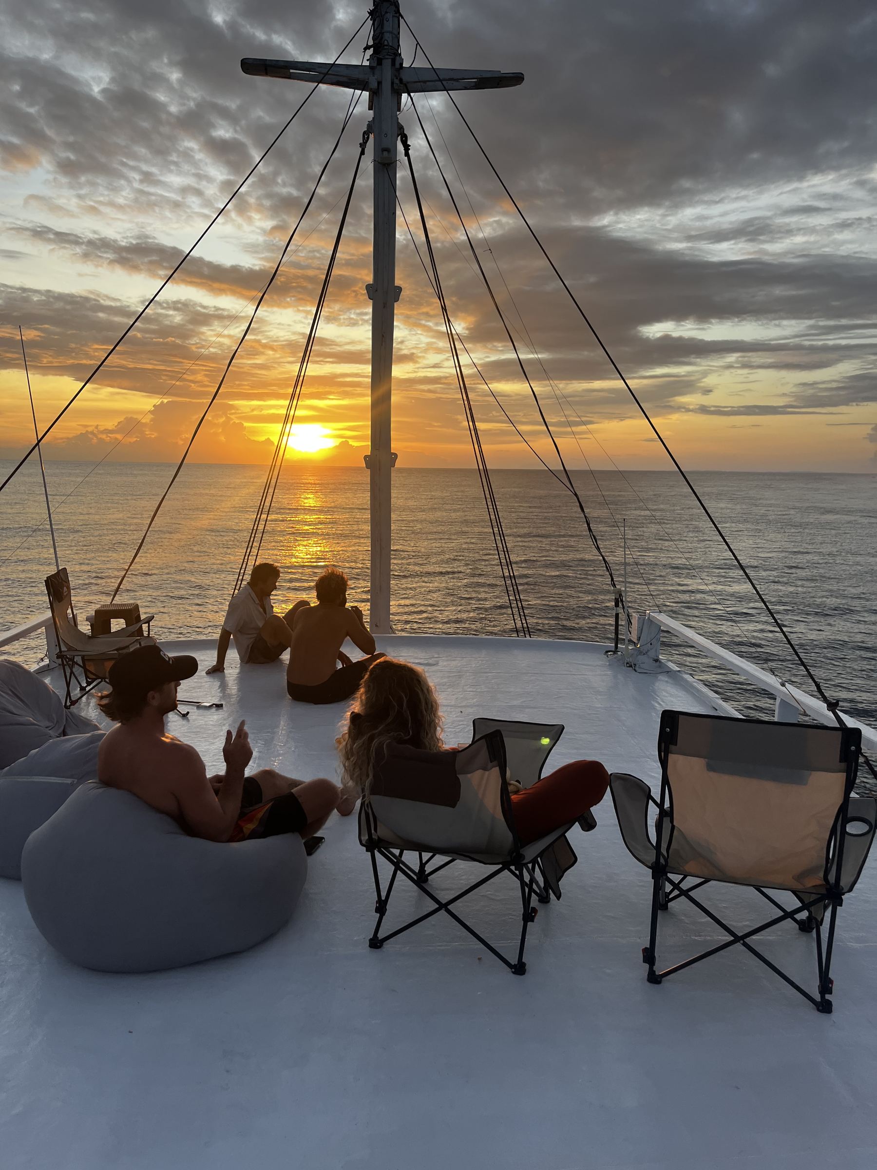 Guests watching the sunset from the bow rigging